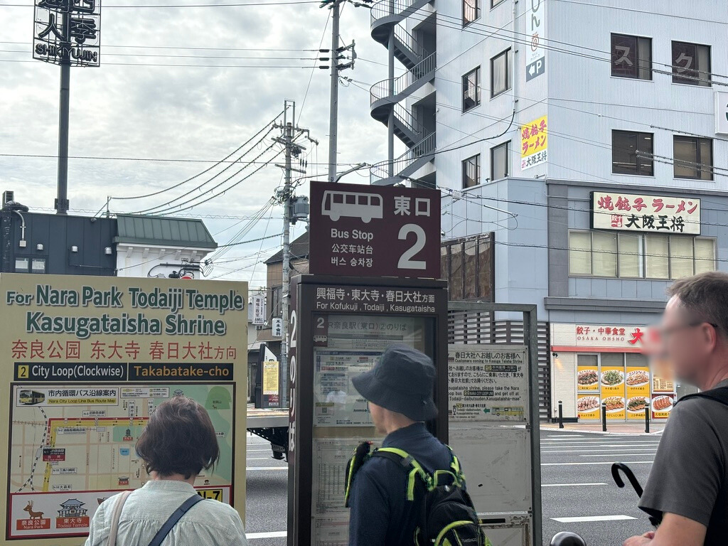 奈良駅で東大寺へ行くバスを待つ人達。 バス停は、東口２と表示されている。