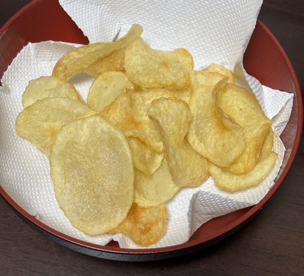 パリッと美味しそうに出来上がったポテトチップス。菓子器にキッチンペーパーを置いた上に20枚ほど乗せてある。