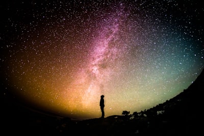 星あかりの中で、星を見上げる一人の男性の画像