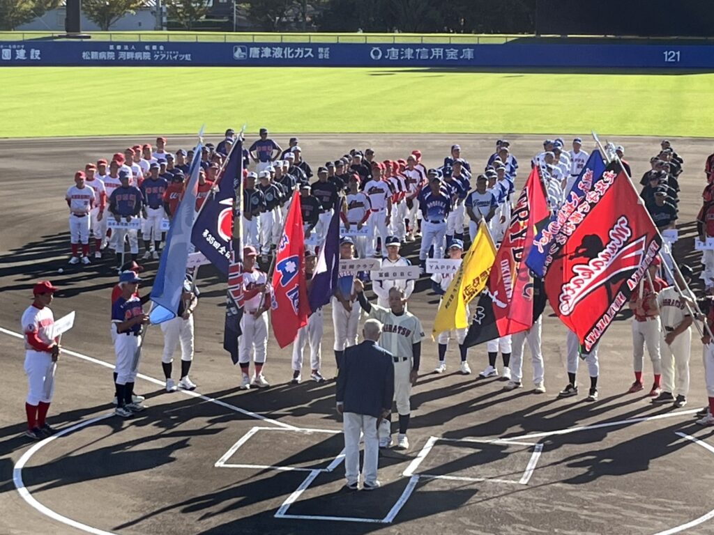 開会式の選手宣誓写真。代表者を各チームの旗で囲んでいる。