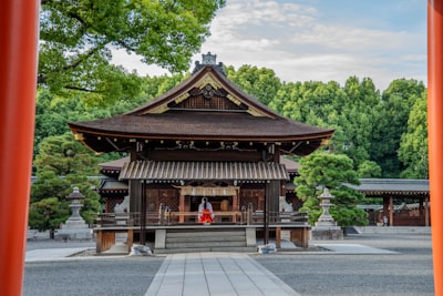 神社境内の写真。巫女さんが作業している。